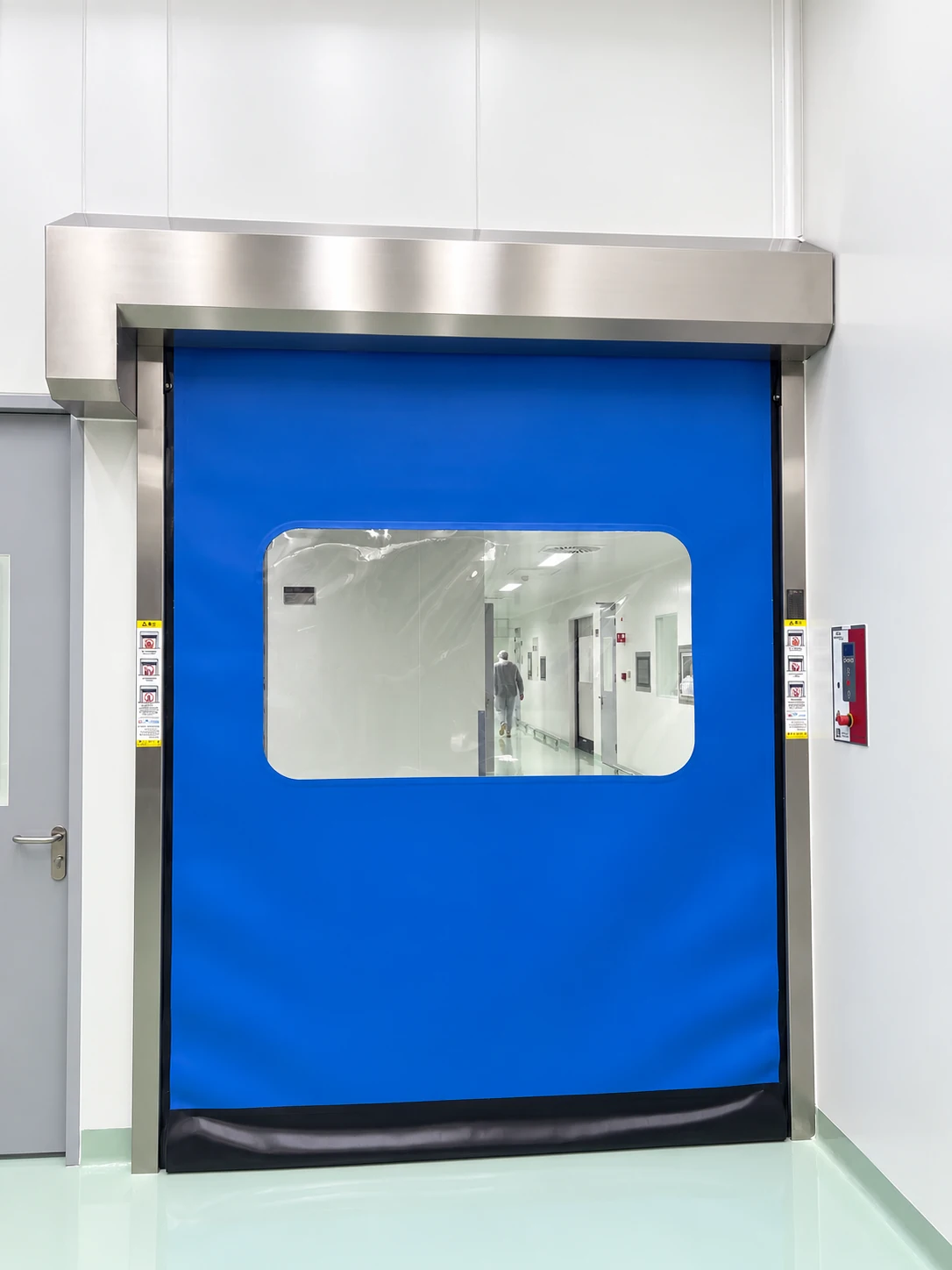 Blue cleanroom door with stainless steel housing, side guides and a viewing panel